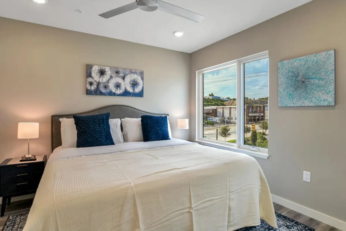 A serene bedroom with a king bed, decorative artwork, and natural light streaming through the windows. The room exudes comfort and privacy, ideal for extended business stays or unwinding after a busy workday.
